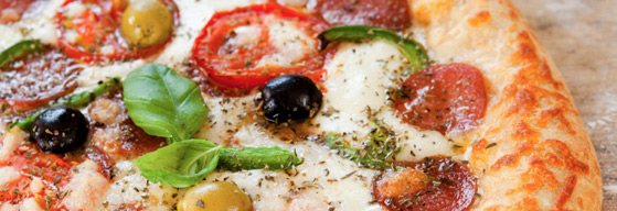 Gourmet Pizza on a plate with olives, herbs and spices